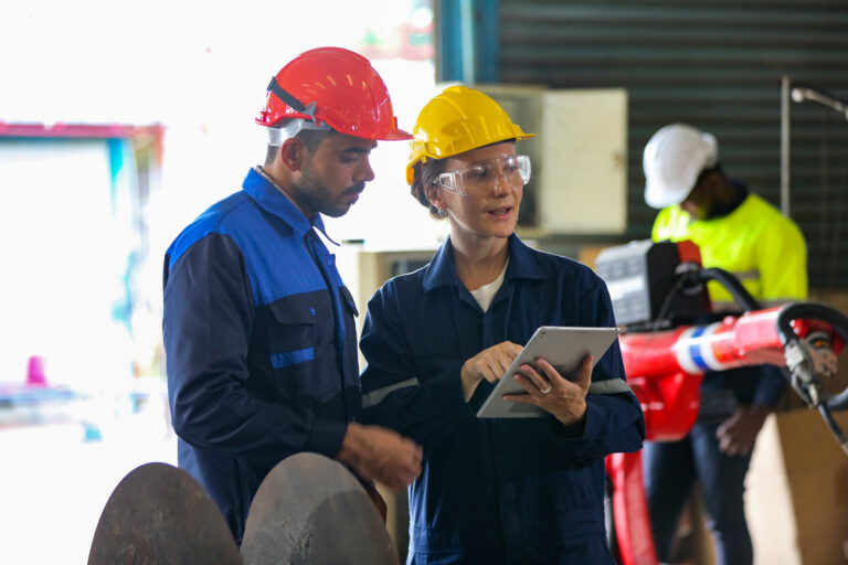 The factory engineer configures a complex production plantThe factory engineer configures a complex production plant engineer checking control panel and teaching new Automatics robot arm and operating control machine in factory.
