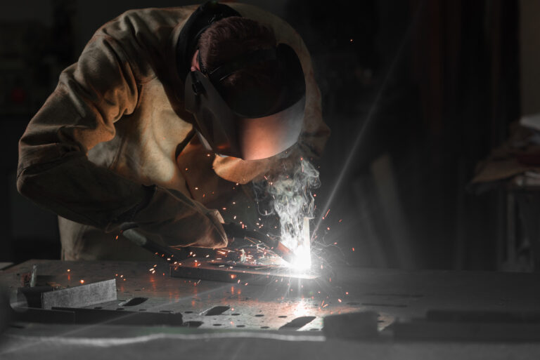worker in protection mask welding metal at factory worker in protection mask welding metal at factory